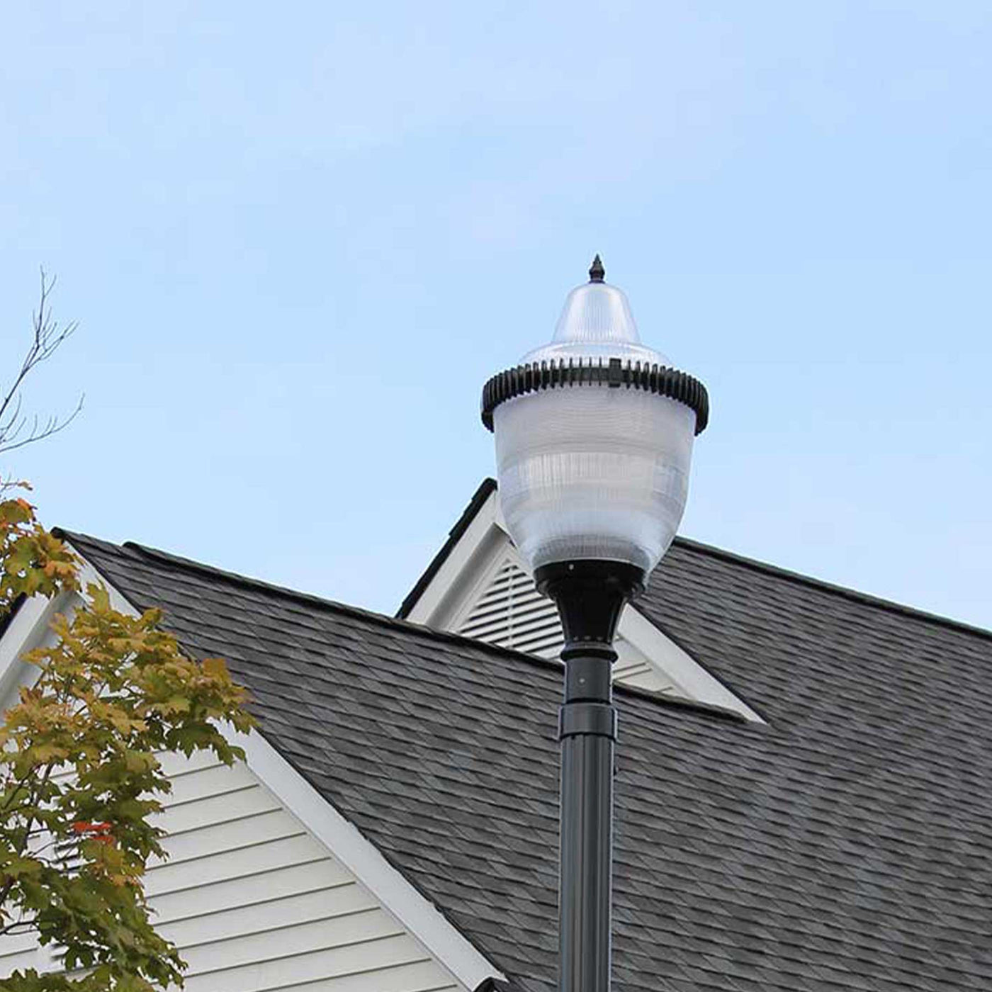 A ring of fire LED post top light in front of a house
