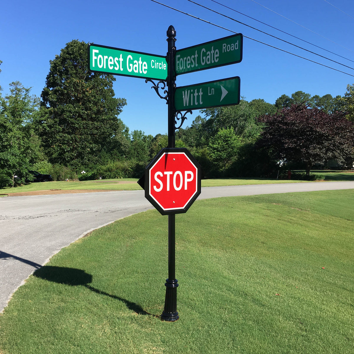 street signs and stop sign on decorative post with cap and base
