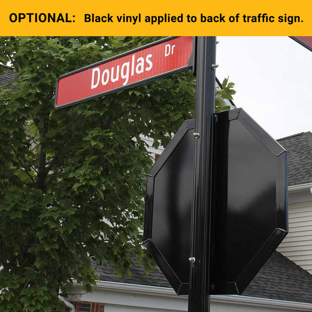 example of optional black vinyl applied to the back of a traffic sign, this image is a stop sign with black back and black frame mounted to a decorative sign post with a street sign above the stop sign