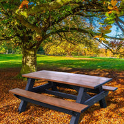 rectangle recycled picnic table 6 ft long  under a tree in a park