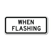 white sign with black text that reads " when flashing" 