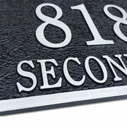 Up-close view of a rectangular, cast aluminum address plaque
