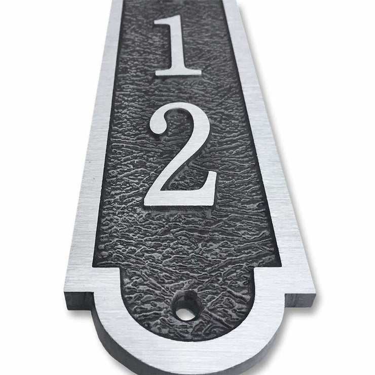 An up-close view of a 3x16 vertical house number plaque made from cast bronze