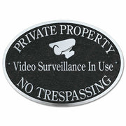 cast aluminum sign with private property video surveillance in use No trespassing with video camera icon in polished aluminum and black background