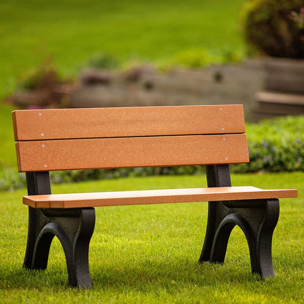 Traditional style park bench made of recycled plastic with cedar top color and black base color. Shown without arms.