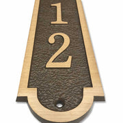 A close-up view of a 3x16 vertical house number plaque constructed from cast bronze