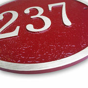 An up-close view of a round house number plaque made from cast bronze