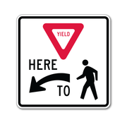 crosswalk sign yield here for pedestrian with arrow left