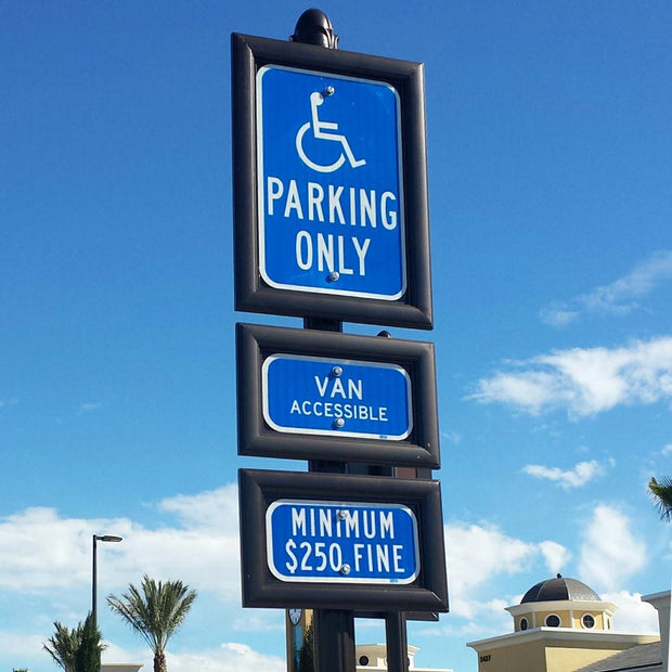 accessible parking signs in black extruded aluminum sign fames installed on a decorative post
