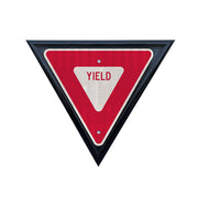 red and white reflective yield sign shown in black triangle yield sign frame