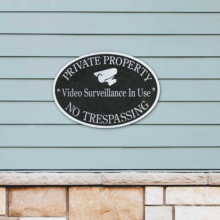private property, no trespassing cast plaque shown mounted to siding on a house